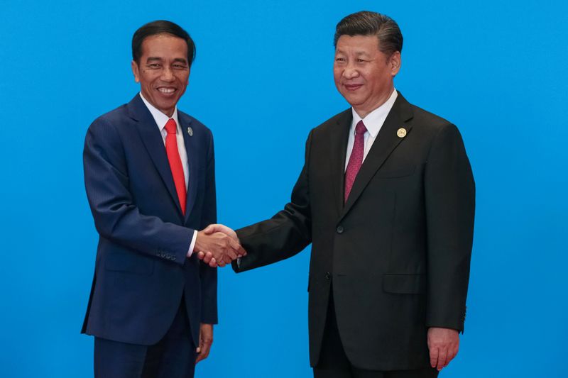 Indonesia’s President Joko Widodo (L) shakes hands with Chinese President