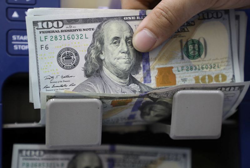 A man counts U.S. dollar banknotes at a currency exchange