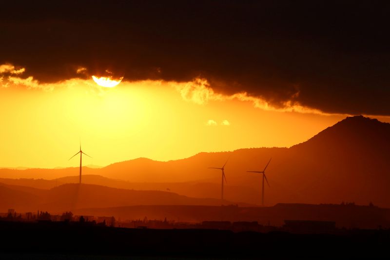 FILE PHOTO: Power-generating windmill turbines are pictured during the sunset