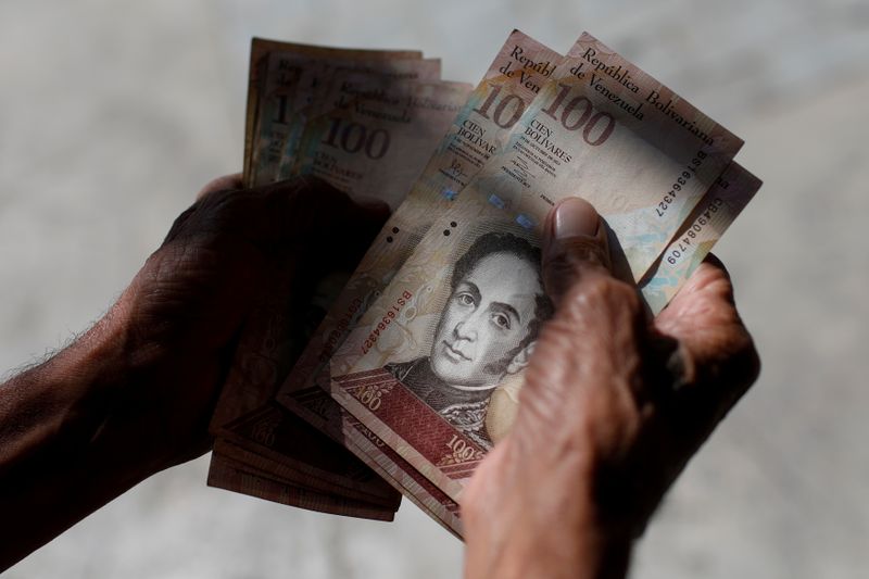 FILE PHOTO: A man counts Venezuelan bolivar notes in downtown