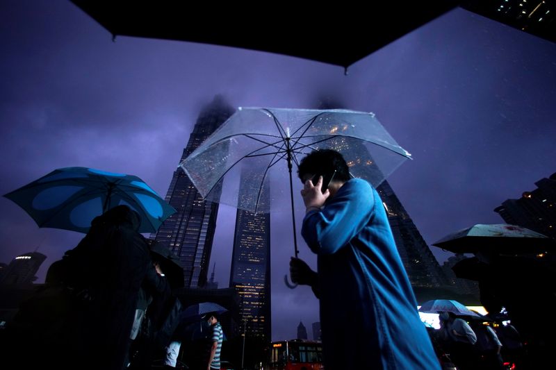 People walk with umbrellas in Lujiazui financial district in Pudong