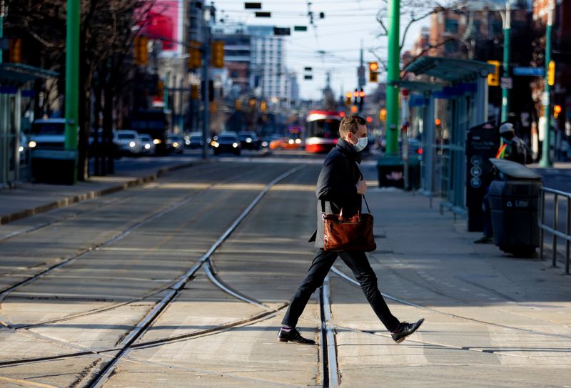 FILE PHOTO: People walk with face masks in Toronto