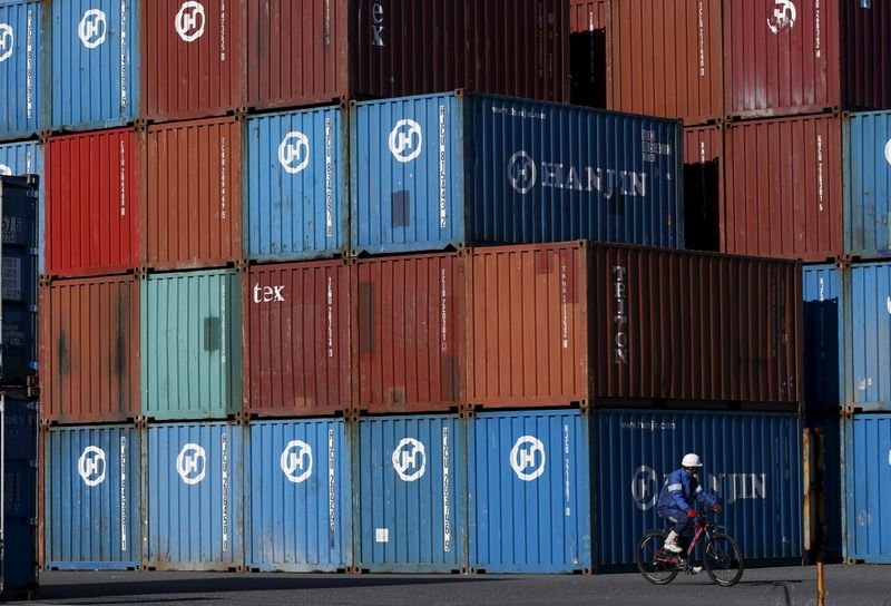 Worker rides a bicycle in a container area at a