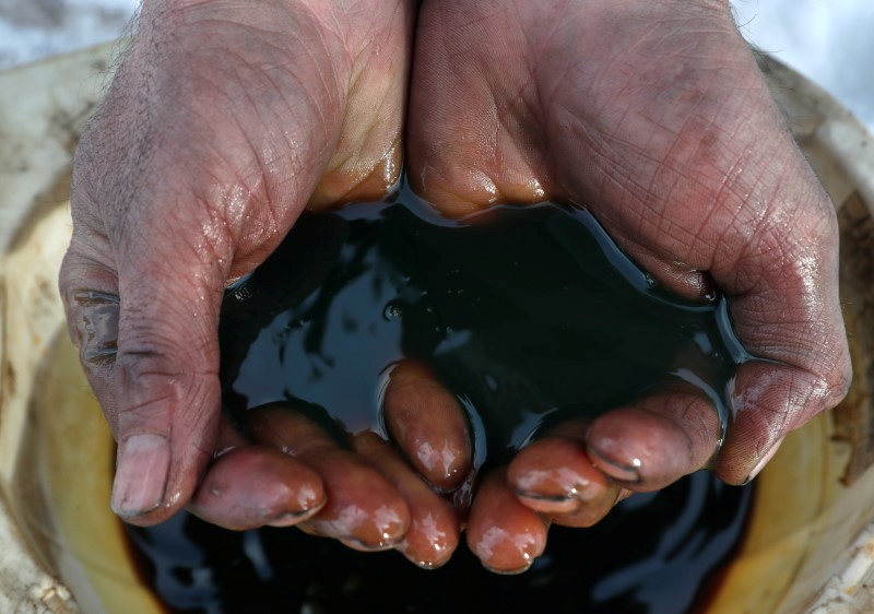 FILE PHOTO: An employee demonstrates a sample of crude oil