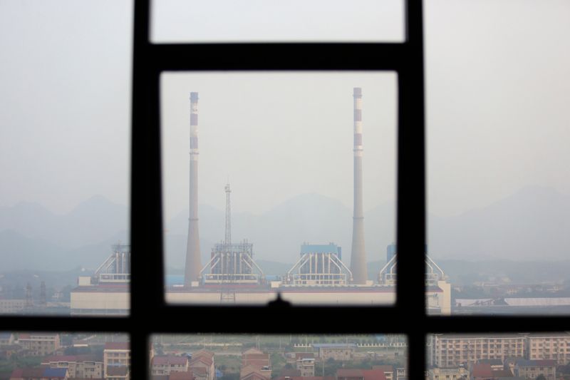 Chimneys are seen through a window at a coal-fired power