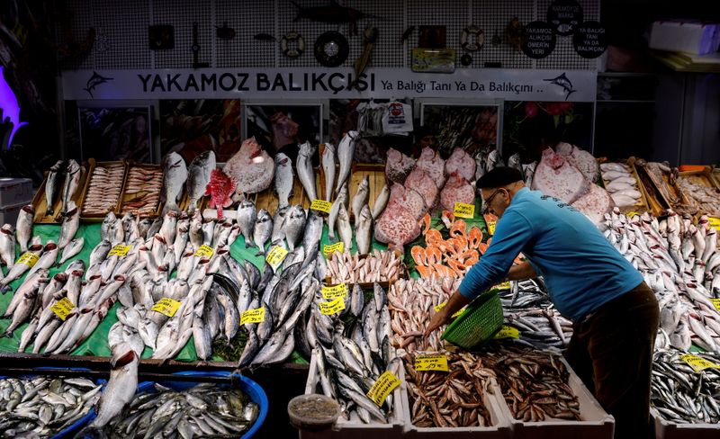 FILE PHOTO: People shop at a fish market at Karakoy