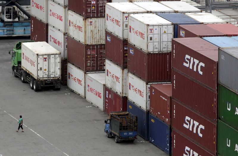 FILE PHOTO: A person walks near containers at Keelung port,
