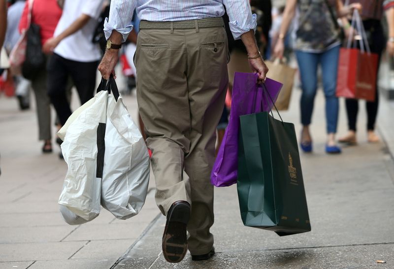 FILE PHOTO: Shoppers carry bags in London