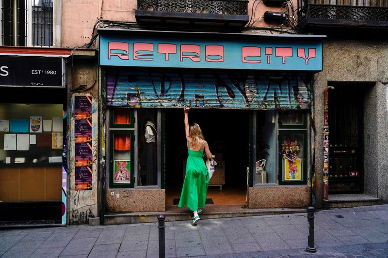 A woman opens a shop at a commercial district in