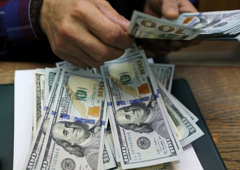 An employee counts U.S dollar bills at a money exchange