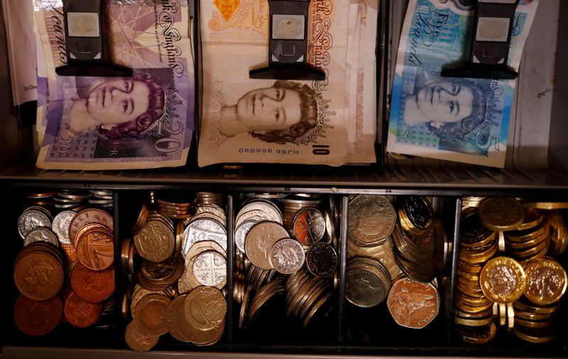 FILE PHOTO: Pound notes and coins are seen inside a