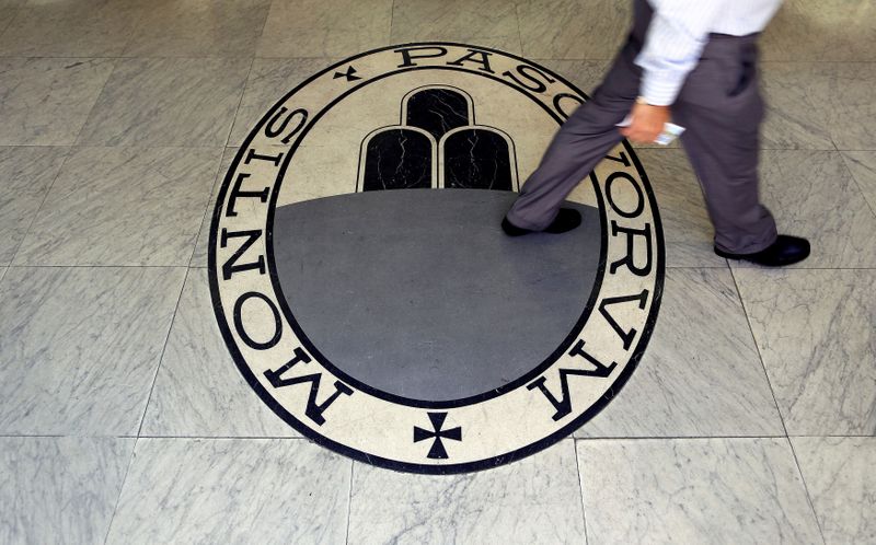 FILE PHOTO: A man walks across the logo of the