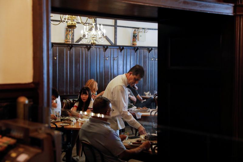 A waiter serves steak at Peter Luger Steak House in