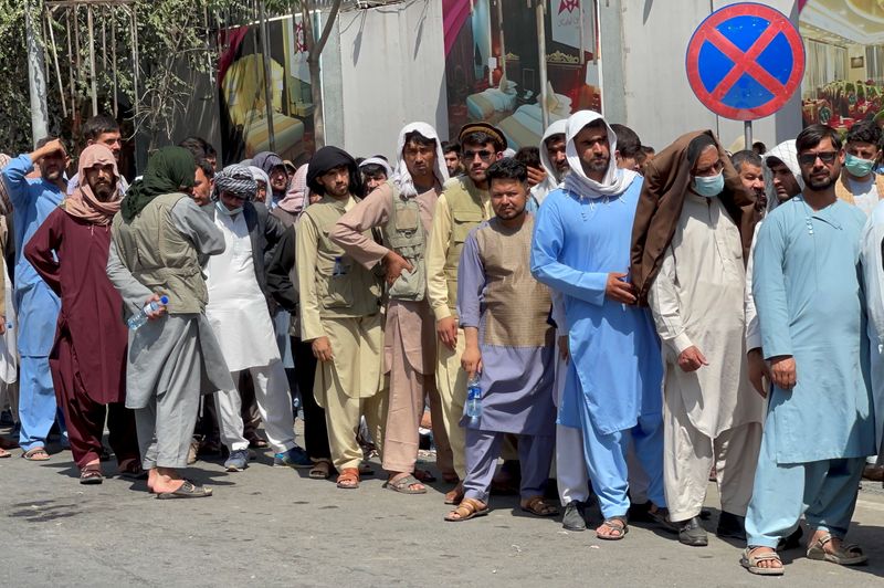 Afghans line up outside a bank to take out their