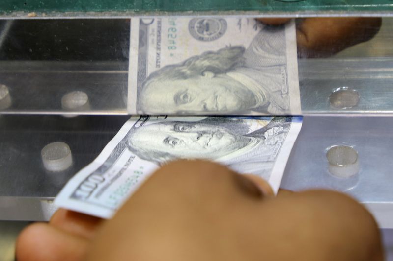 Man inserts a U.S. dollar banknote into the window of