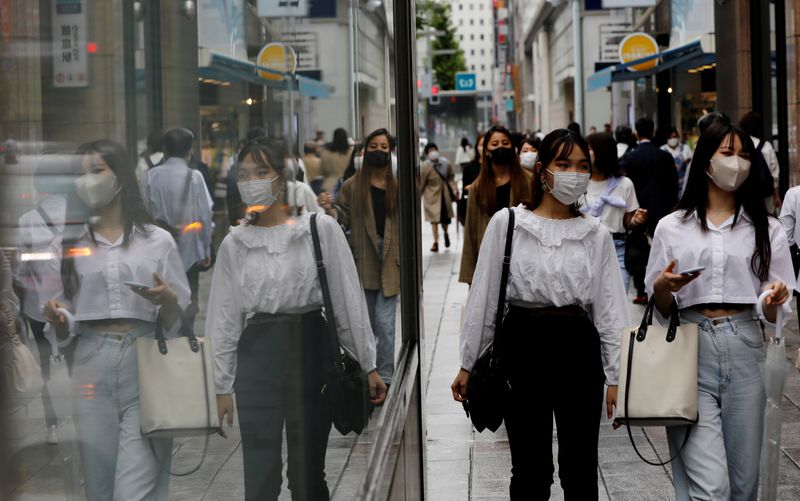 FILE PHOTO: People wearing protective masks in a shopping district