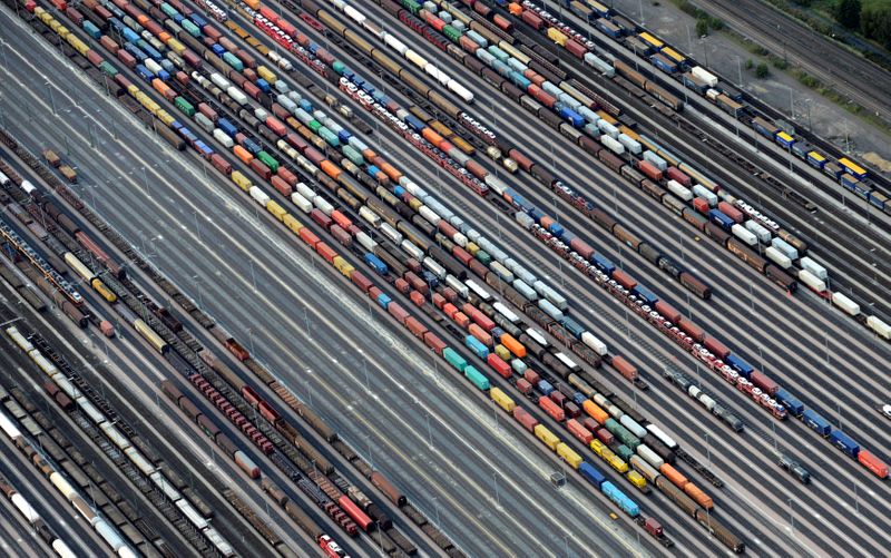Containers and cars are loaded on freight trains at the
