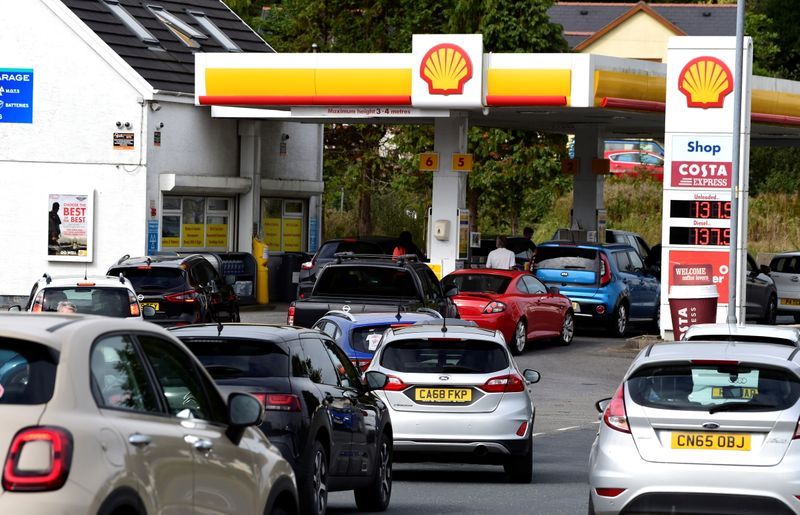 Cars queue up at a petrol and diesel filling station