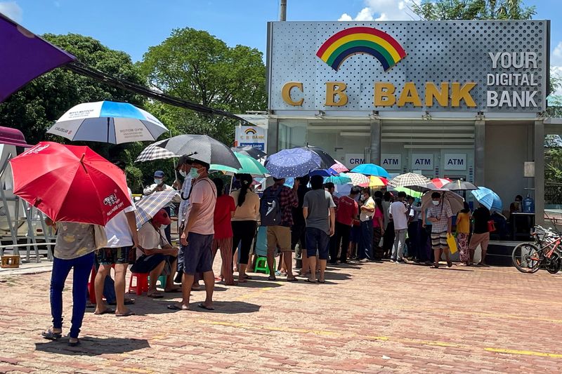 FILE PHOTO: People line up outside a bank to withdraw