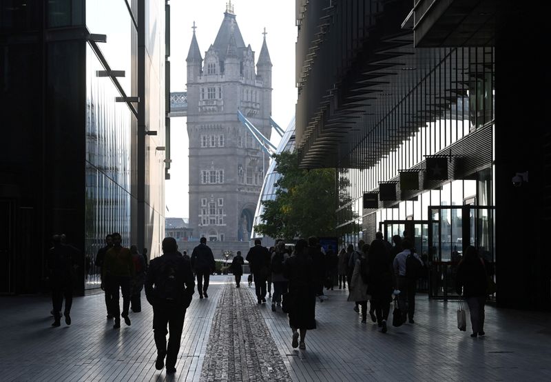 FILE PHOTO: Workers walk towards Tower Bridge during the morning