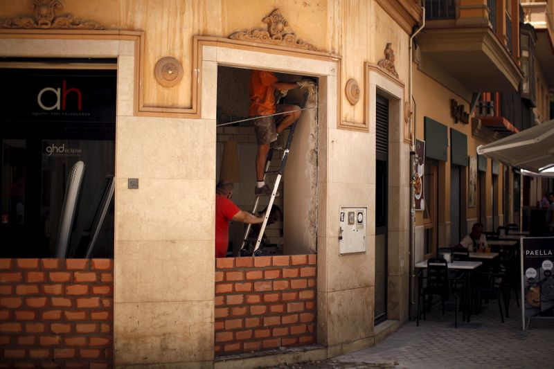Workers work inside a hairdressing salon in downtown Malaga