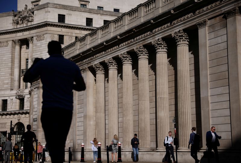 FILE PHOTO: People walk past the Bank of England during