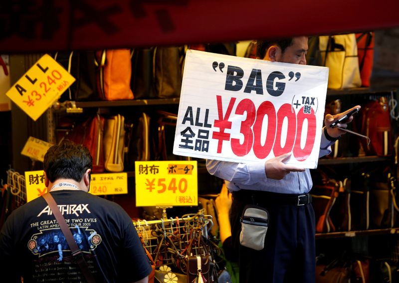 FILE PHOTO: A shop employee holds a placard to attract
