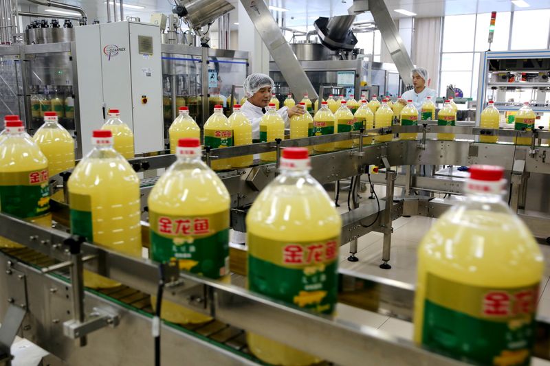 Men work at a production line of soybean-based cooking oil