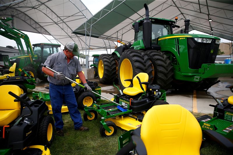 FILE PHOTO: A man cleans farm machinery as people prepare