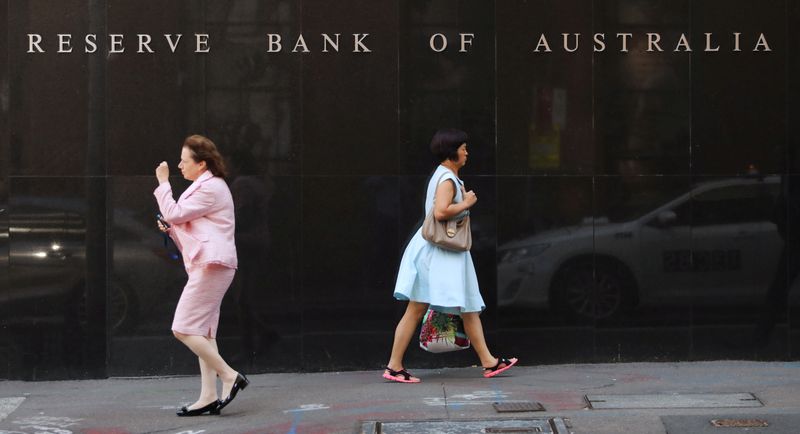 Two women walk next to the Reserve Bank of Australia