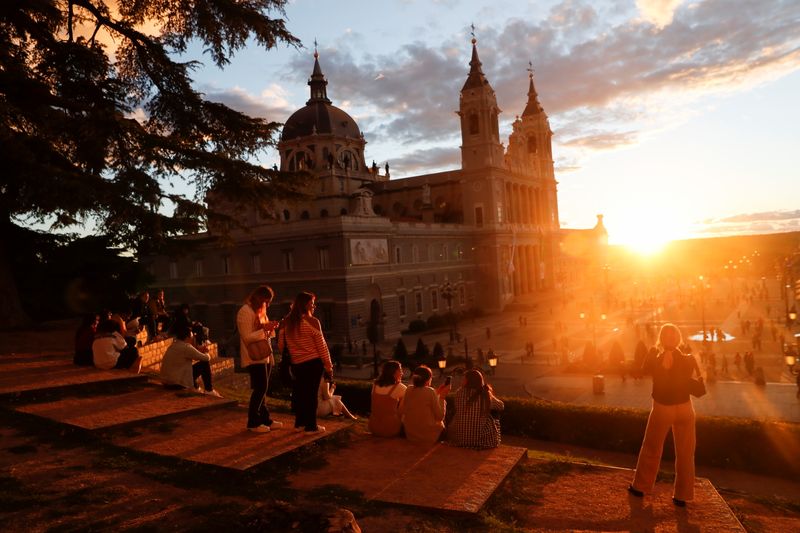 Tourists and locals watch the sunset by La Almudena Cathedral