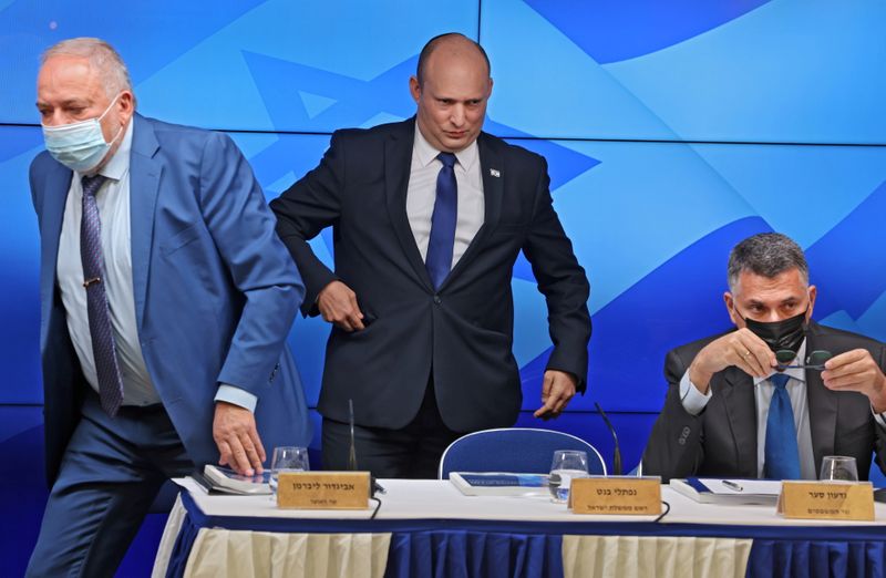 FILE PHOTO: Israeli Prime Minister Naftali Bennett stands between Finance