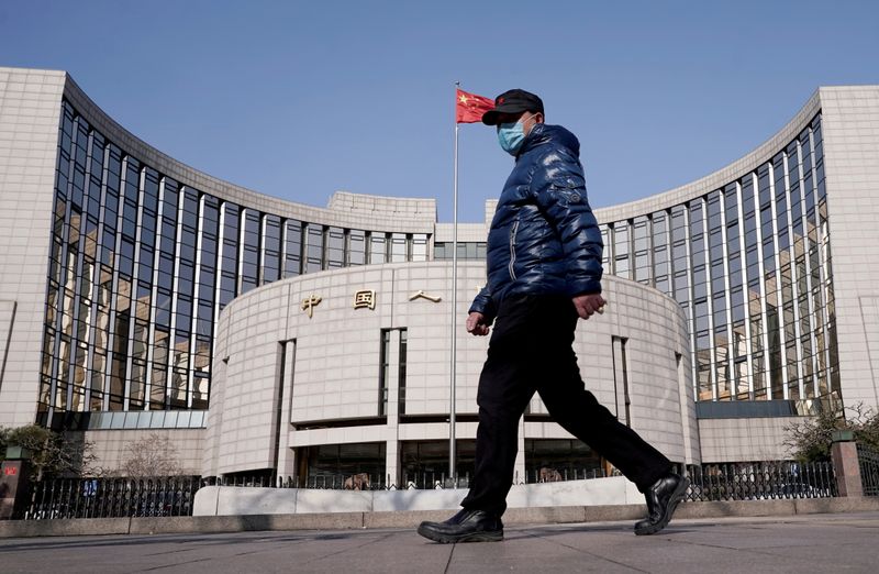 FILE PHOTO: FILE PHOTO: Man wearing a mask walks past