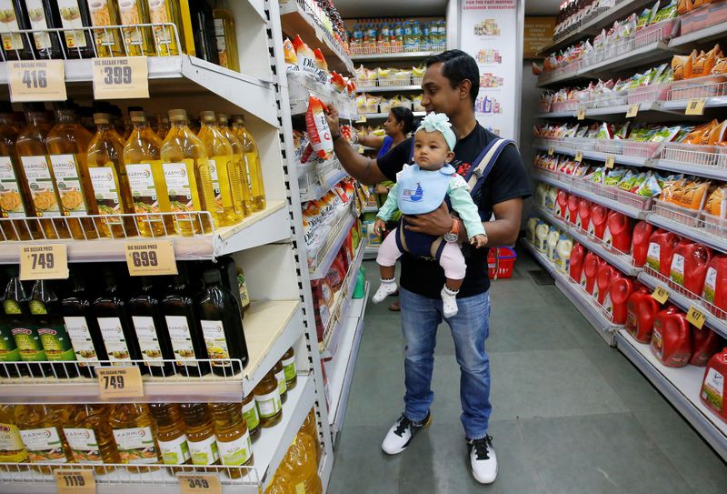 A customer carries his daughter as he buys goods at