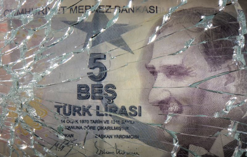 FILE PHOTO: Broken glass is placed over Turkish Lira banknote