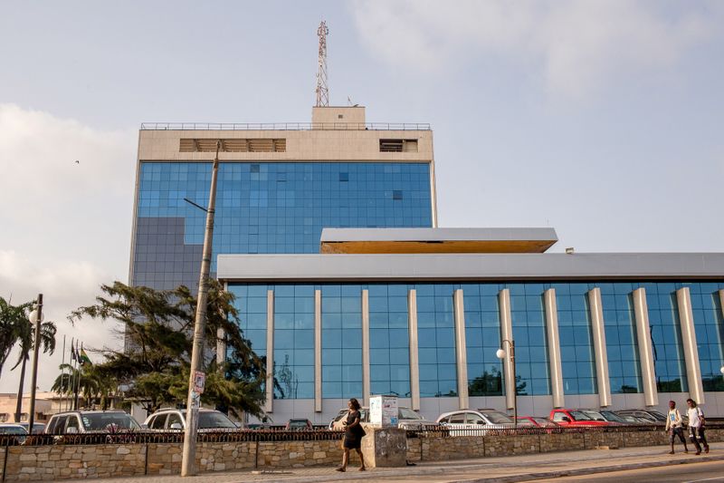 Pedestrians walk in front of Ghana’s central bank building in