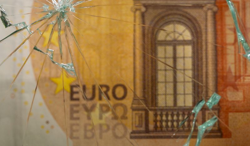FILE PHOTO: Euro banknote is seen through broken glass in