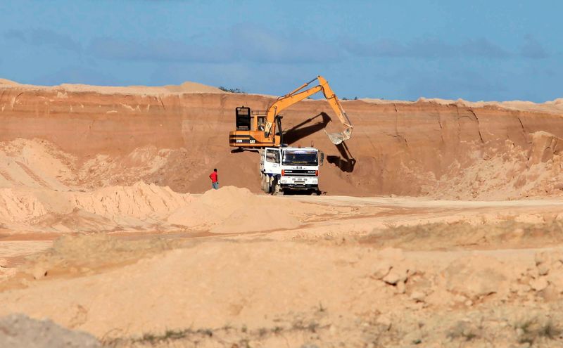 FILE PHOTO: A excavator dumps bauxite ore into a dump