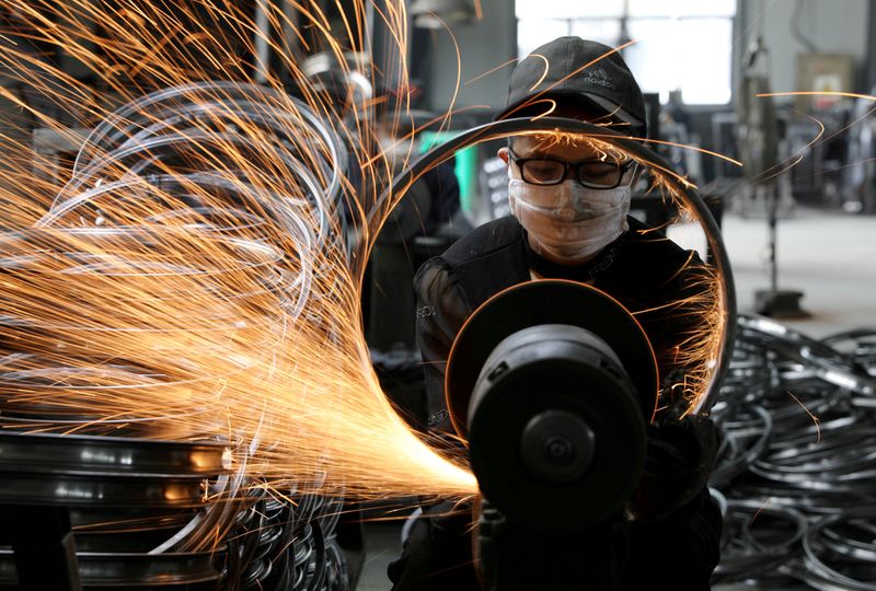 FILE PHOTO: Worker welds a bicycle steel rim at a