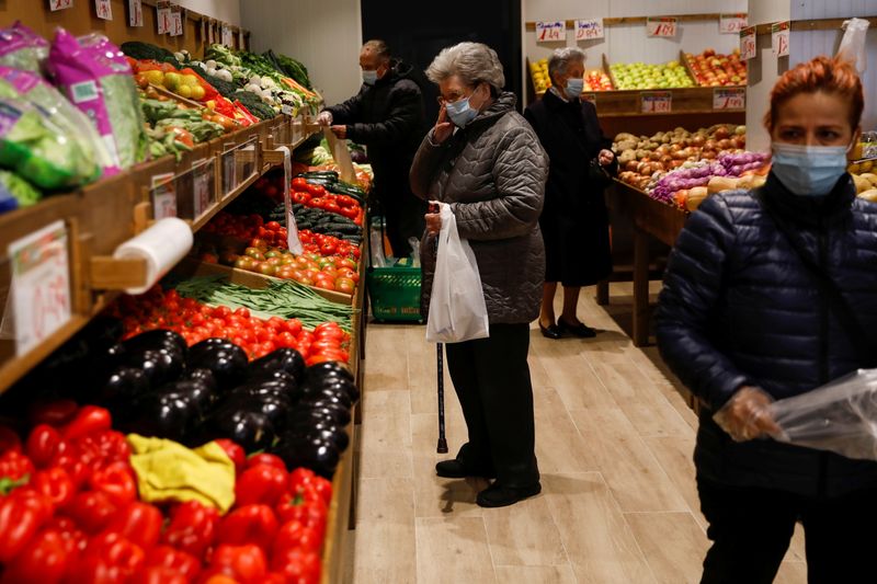 People shop at a fruit store in Madrid