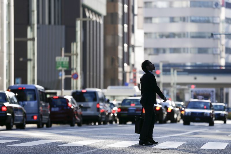 A businessman looks up as he crosses a street in
