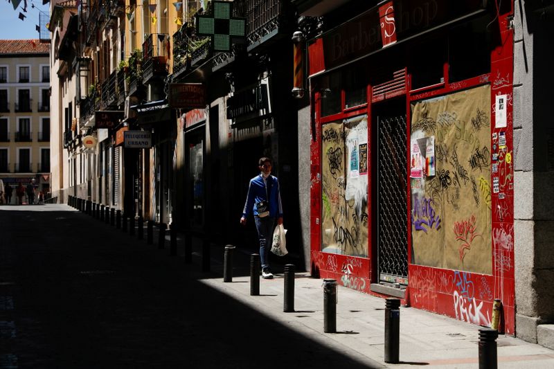 FILE PHOTO: A man walks past a closed down business