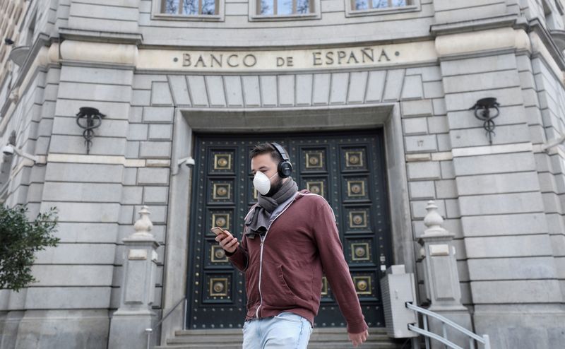 FILE PHOTO: A man walks past the Bank of Spain