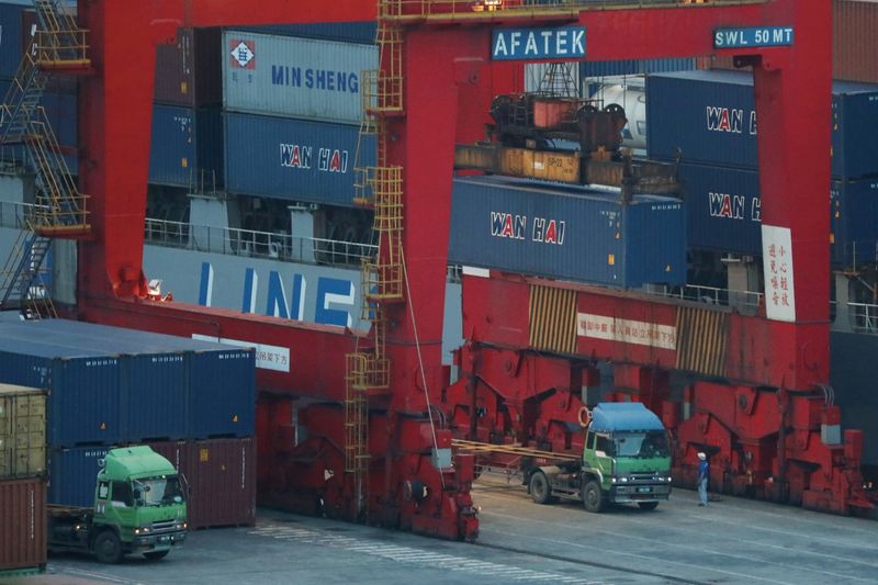 FILE PHOTO: Trucks wait to be loaded on with containers