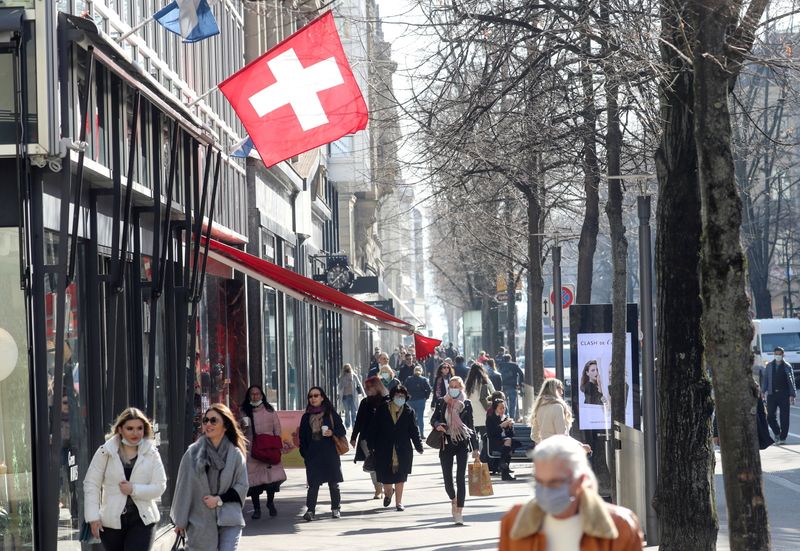 FILE PHOTO: Shoppers walk along the street after the Swiss