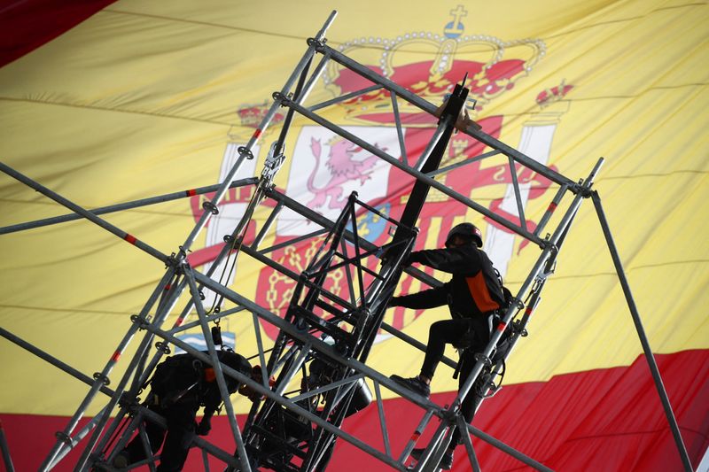 Workers set up a huge scaffold as a Spanish flag