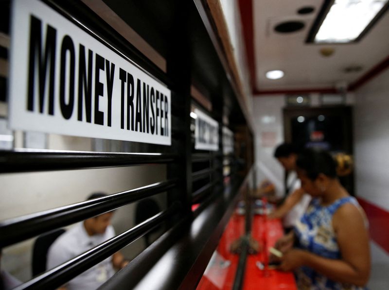 Customers receive money from families working abroad at a money