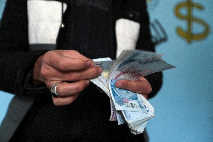 Hassan al-Khalaf counts Turkish lira banknotes in Idlib, Syria