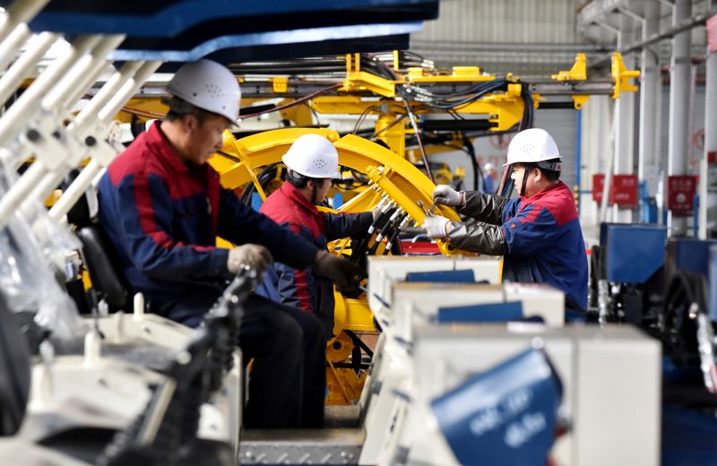 Employees work on a drilling machine production line at a