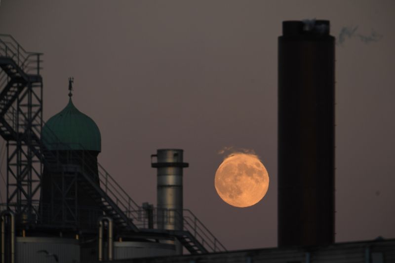 A strawberry moon is seen over chimneys at the Guinness